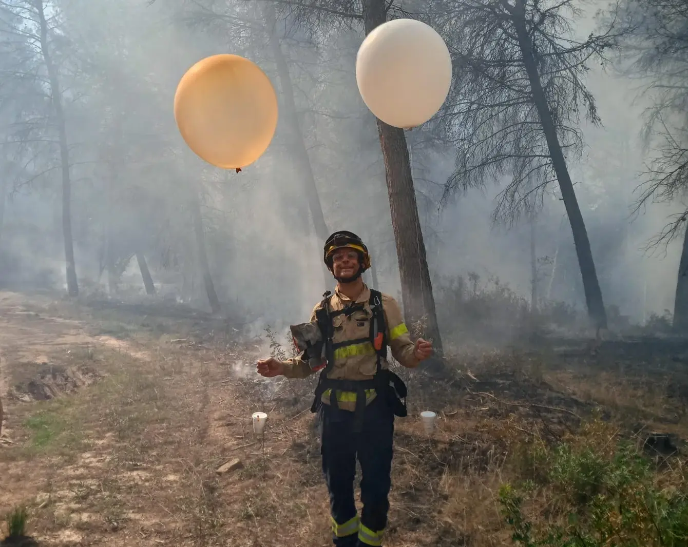 Firefighter in Spain releasing two Windsond next to a fire.